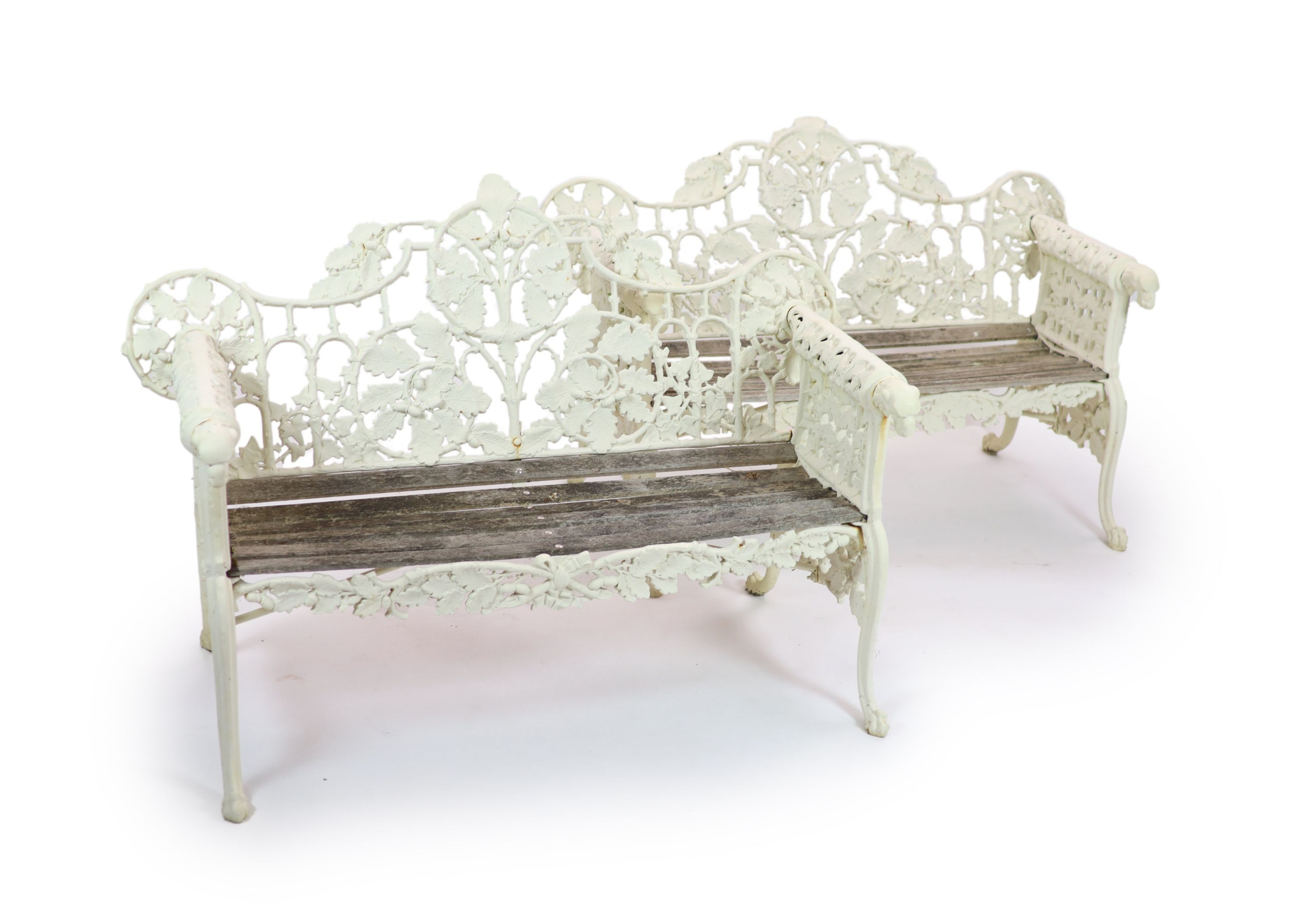 After Coalbrookdale, a pair of cast iron ‘Oak and ivy' benches H 95cm. W 148cm. D 68cm.
